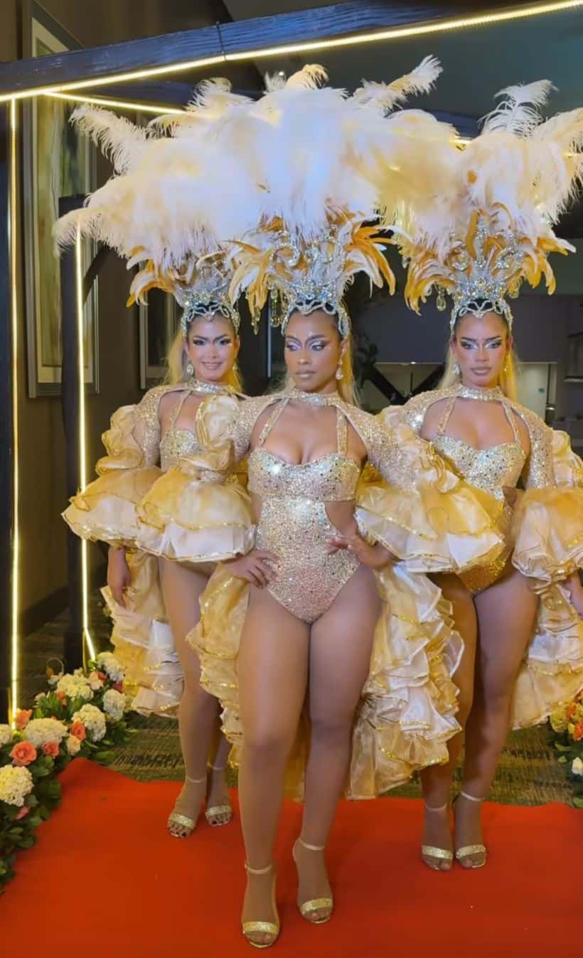 FloDivinas showgirls in gold crystal bodysuits and white feather headdresses at a Naples, Florida event